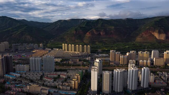 Stunning aerial drone footage of Xining city showcasing modern architecture, illuminated highway bridges, and vibrant night lights against the mountainous Qinghai landscape.