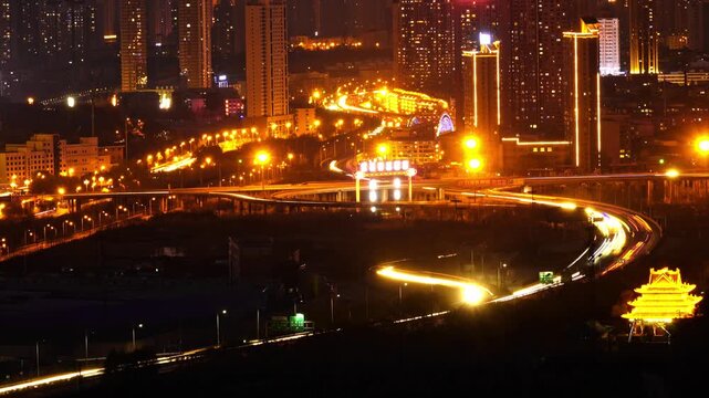 Stunning aerial drone footage of Xining city showcasing modern architecture, illuminated highway bridges, and vibrant night lights against the mountainous Qinghai landscape.