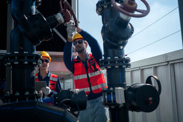 Naklejka premium Engineers inspecting industrial pipeline and valve systems