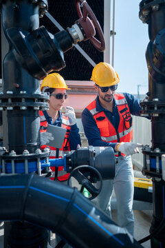 Engineers inspecting industrial pipeline and valve systems
