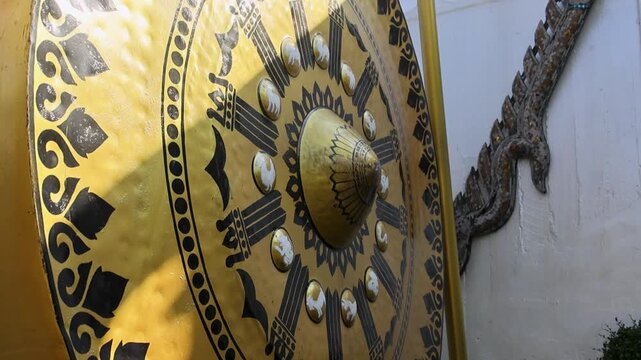 Visitor Striking Large Temple Gong at Wat Saket Golden Mount Bangkok Thailand