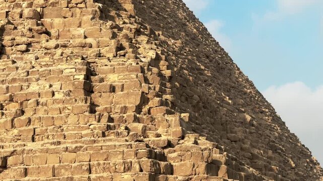Stone blocks on the angle of Pyramid of Khafre apex with original limestone casing remnants. Tilt up detailed cinematic motion shot