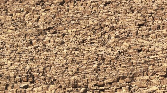 Illuminated side of Pyramid of Khafre apex with original limestone casing remnants. Tilt up cinematic close up motion 