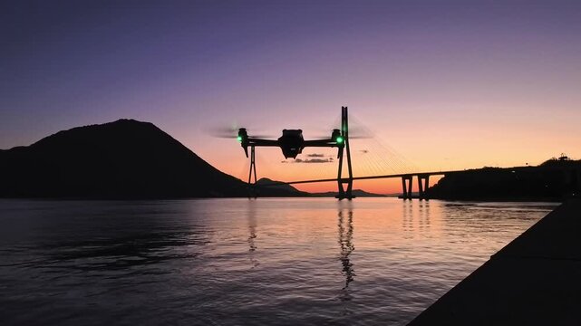 Cinematic drone departure towards Tatara Bridge at dawn, centrally framed with ample copy space for text and graphics.
