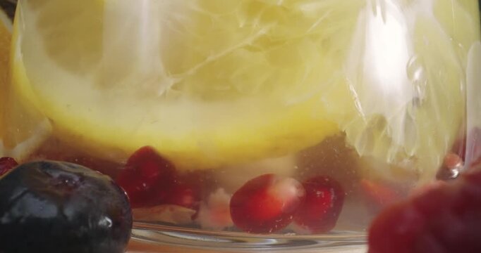 Mixing a fresh healthy berries juice in glass jar with macro shot of various fruits, probe dolly shot