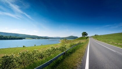 Fototapeta premium Scenic Country Road By A Lake Under A Clear Sky