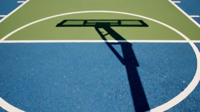 A basketball successfully goes through the hoop against a clear blue sky
