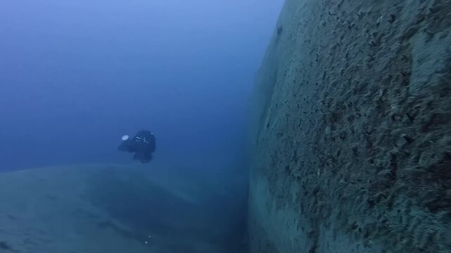 Blue Deep Scuba Diving Adventure at Gozo Azure Window Ruins Featuring Professional Diver Exploring Underwater Limestone Formations Under Clear Mediterranean Summer Skies with Wide Angle View
