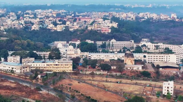 Gurudwara Sri Nanak Jhira Sahib with greenery, fog and buildings at bidar, karnataka, india. day time, tilt up shot, push back shot, drone shot, 4k.