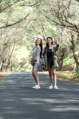 Fototapeta premium Asian Indonesian Women Friends Taking Selfie on Forest Road