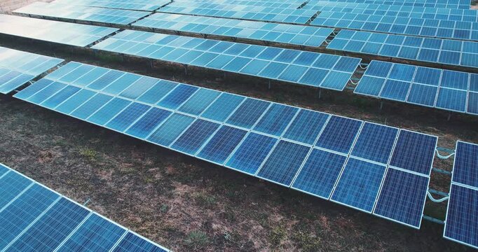 Photovoltaic farm - renewable energy from sunlight - photovoltaic panels set on a green field. Renewable energy supplying medium-sized enterprises, aerial veiw