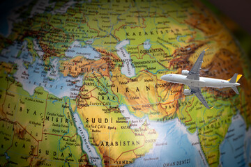 Naklejka premium Flight cancellations due to the war. The plane is flying over the map of Iran. War tensions caused flight restrictions. Aviation idea concept. Middle Eastern countries. Travel. No people, nobody. Top 