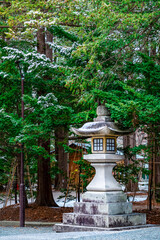 Fototapeta premium Traditional Japanese Stone Lantern in a Peaceful Winter Forest, Snowy Landscape.