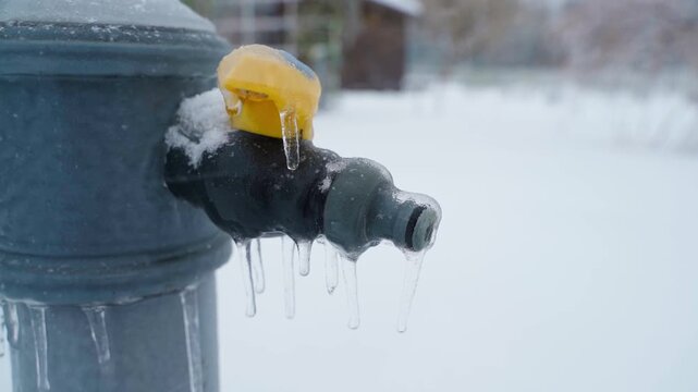 Frozen in winter street tap for connecting water hoses, close-up
