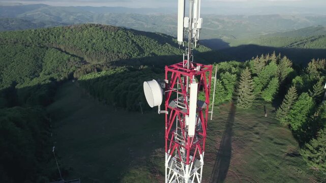 Telecommunication tower with cellular antennas for 5g mobile internet network on forest and blue sky background