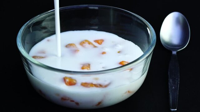 Pouring coconut milk into a glass bowl with tapioca balls. Tapioca balls in coconut milk is traditional dessert in Thailand.