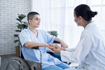 Fototapeta premium Doctor hold senior woman hands who sit on wheelchair with concept of take care and support elderly people in clinic or hospital center