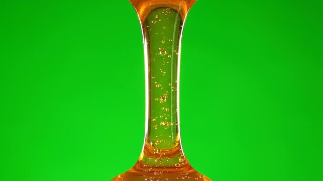 Golden Honey Dripping in Smooth Stream on Green Screen Background