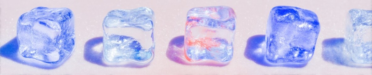 Obraz premium Blue ice cubes in a row for refreshing cold drink advertisement with pink and purple shadows for beverage branding and summer product display on a wide background