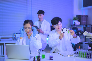 Researchers team of science. A man research scientist and woman preparing and analyzing microscope...