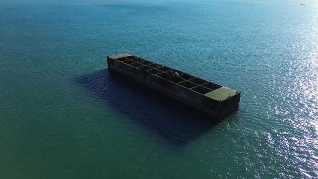drone footage capturing the historic WW2 Mulberry Harbour in Asnelles under bright sunshine