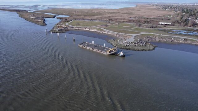 Aerial view of barge along shorlien full of mud form dredging river.