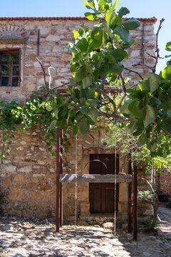 Stone courtyard and wooden door at Nea Moni Greek Orthodox monastery on Chios island, Greece