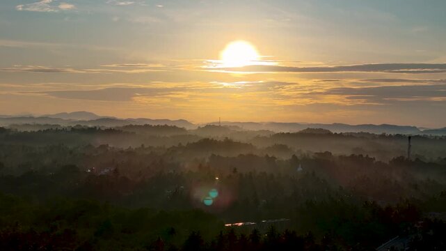 4K scenic morning sunrise shining over a vast misty tropical valley and rural landscape