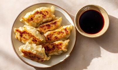 Top-down view of a plate of freshly cooked Japanese gyoza, golden brown and crispy on the bottom