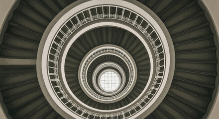 Fototapeta premium View from below of a spiral staircase with multiple landings and railings in a modern architectural setting