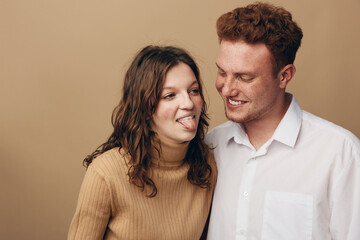 Young couple having fun together, woman playfully sticking out tongue while man smiles. Casual...