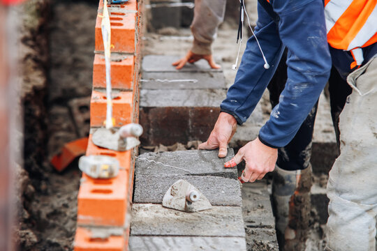 Construction worker laying concrete blocks on building site