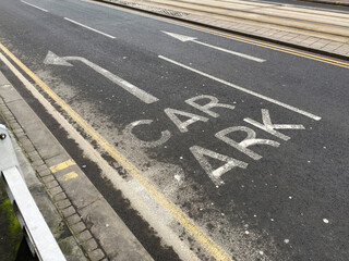 Fototapeta premium Car park road markings with arrows and tram tracks in Manchester UK street scene