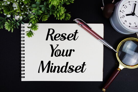 Reset Your Mindset text with alarm clock and magnifying glass