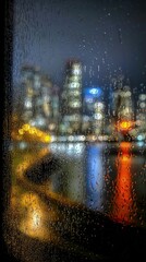 Fototapeta premium Rainy Night Cityscape Through Window