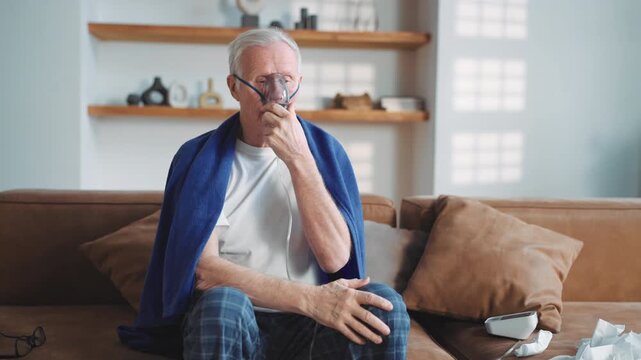 Modern technology in medicine, old man using oxygen machine with nebulizer. Senior sick male person inhaling concentrated oxygen from nebulizer, recovery breathing and relive hypoxia after pneumonia