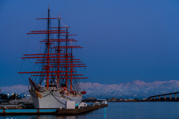 夕方の海王丸パークから新湊大橋と海王丸を前景にピンク色染まる立山連峰アーベンロート