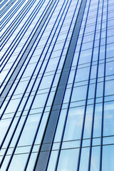 Obraz premium Tall glass curtain wall rising across urban office tower