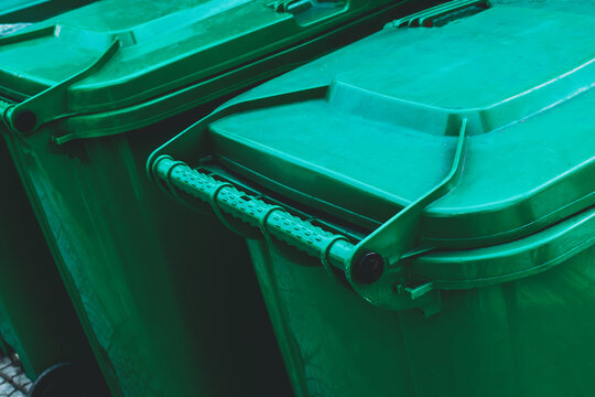 Green waste bins sealed and aligned on city sidewalk