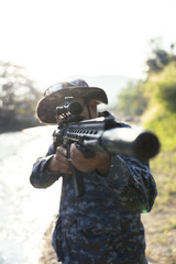 Obraz premium Focused soldier in camouflage aiming rifle during military combat mission outdoor. weapon is ready for action, showing intense concentration and preparedness for battle
