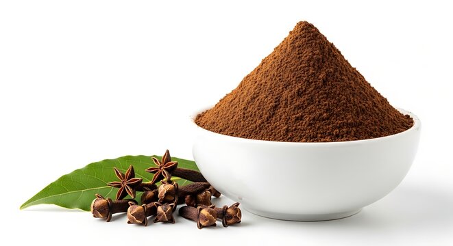 Close-up of a bowl of ground cloves with whole cloves and a leaf.