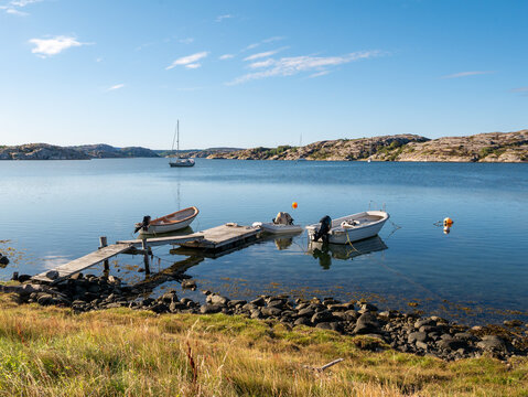 H&aring;holmdjupet inlet at Val&ouml;n, Bohusl&auml;n, Sweden, with small boats and wooden jetty looking toward L&aring;ng&ouml; across calm water in west coast archipelago