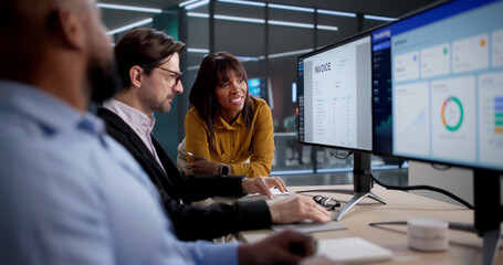 Diverse Team Of Office Workers Analyzing Billing Spreadsheets On Computers
