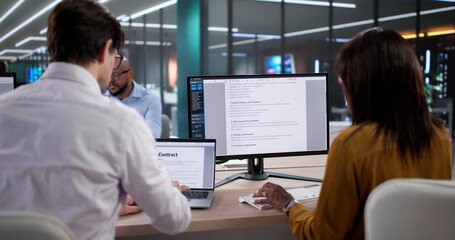 Diverse Compliance Team Reviews Confidential Patient Data On Laptops