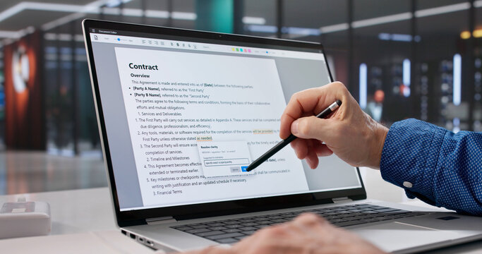 Mature Caucasian Man Proofreading Document On Laptop