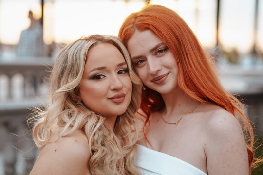 Two Teens in Prom Dresses, Embracing, Sunset Background