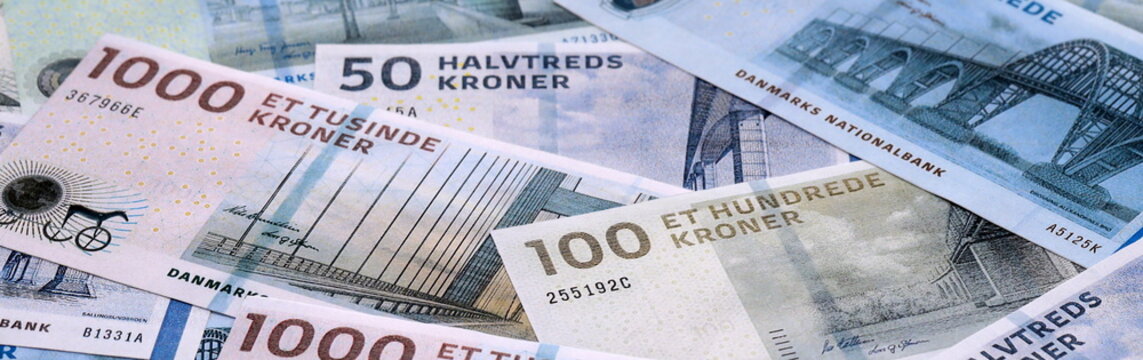 Danish krone money bills pile on table. Denmark banknotes of DKK currency close up.