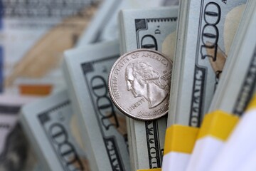 US coin lies among ten thousand dollars packs in stack on big amount of hundred dollar bills © Larysa