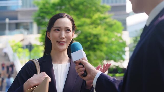 街頭インタビューを受ける女性ビジネスパーソン