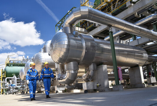 group of workers professional equipment in a petroleum refinery - modern buildings and industrial facilities for the production of fuel and gas